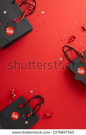 Bargain hunt on Black Friday! A top-down vertical view of stylish paper bags, sale tags, festive tinsel, and star confetti on a vibrant red surface, with space for your advertising text