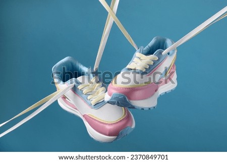 Pair of stylish sneakers on light blue background