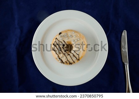 White Chocolate Donut served in plate isolated on blue background top view of baked food breakfast on table
