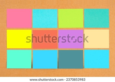 Multicolored of blank sticky notes on wooden board for your text or message.