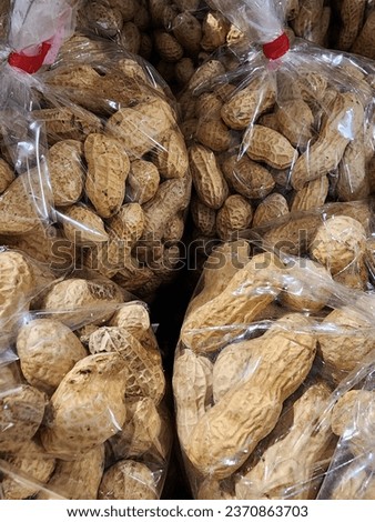 
"GROUNDNUT". The picture shows peanuts packed in plastic containers for sale.