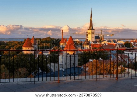 Classic Tallinn cityscape with Saint Olaf's church and old town walls and towers at autumn sunset, Estonia