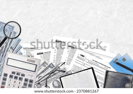 IRS form 1065 U.S. Return of partnership income lies on flat lay office table and ready to fill. U.S. Internal revenue services paperwork concept. Time to pay taxes in United States. Top view Royalty-Free Stock Photo #2370881267