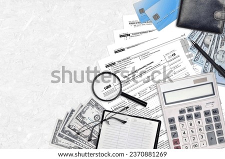 IRS form 1065 U.S. Return of partnership income lies on flat lay office table and ready to fill. U.S. Internal revenue services paperwork concept. Time to pay taxes in United States. Top view Royalty-Free Stock Photo #2370881269