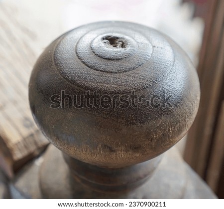 a metal knob on a wooden stand..