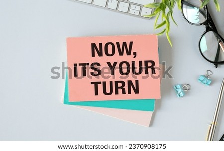 Keyboard, notebook, pen and glasses on blue background , text NOW ITS YOUR TURN. Royalty-Free Stock Photo #2370908175