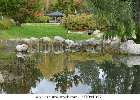A japanese garden with a small pagoda in the autumnal landscape