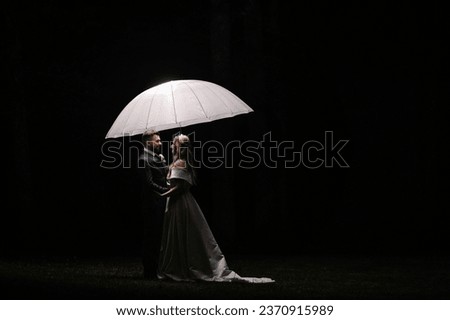 Night picture newlyweds under a light umbrella