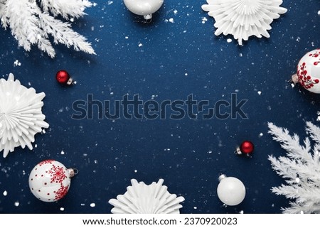 Merry Christmas and Happy Holidays greeting card, frame, banner. New Year. Noel. White Christmas white and red ornaments on blue background top view. Winter holiday xmas theme. Flat lay. Royalty-Free Stock Photo #2370920023