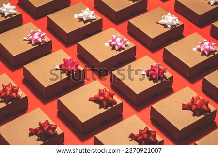 Kraft paper gift boxes with pull bow ribbons flat lay on red background