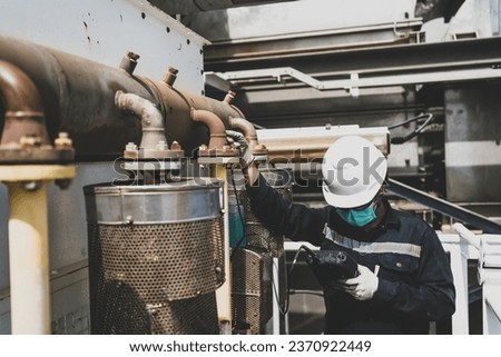 Non-destructive testing technicians are checking the thickness of elbow tubes using ultrasound (UT) testing methods, ultrasound testing to determine the residual thickness after use. Royalty-Free Stock Photo #2370922449