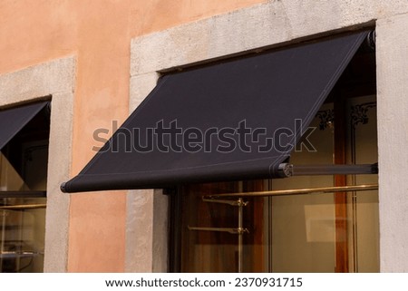 Premium black awning, outside a shop or restaurant, presenting an excellent space for logo mockup promotion