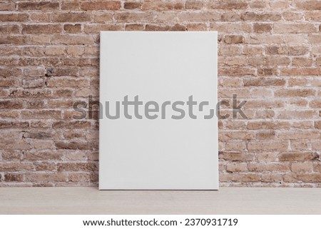Blank art canvas leaning against the brick wall. Clean surface for mockup, art presentation