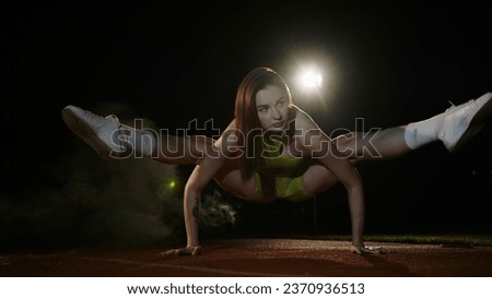 girl doing stretching sitting on a string. gymnast for training. attractive young woman in sportswear is engaged in yoga.