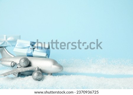 Airplane with gifts and snow on a blue background.