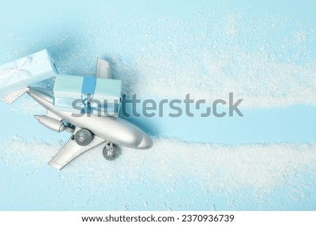 Airplane with gifts and snow on a blue background.