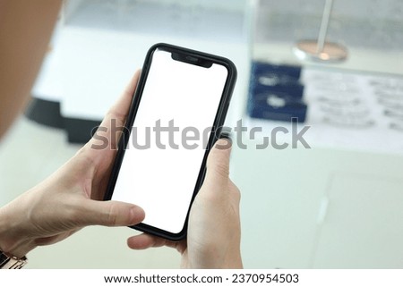 Closeup of hand holding black smartphone white screen.