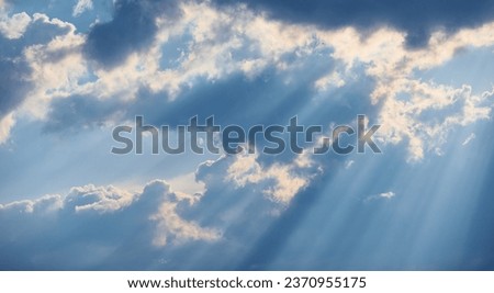 The sun's rays break through the blue clouds. The background of the sky. Royalty-Free Stock Photo #2370955175