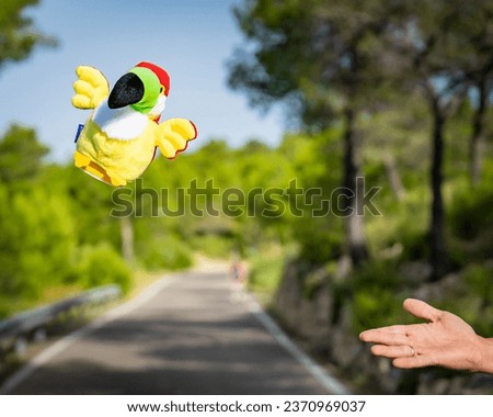 Toy bird flying with forest behind