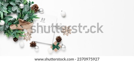 Paper calendar for December 12 with mistletoe wreath, gift and Christmas decorations on white background with space for text