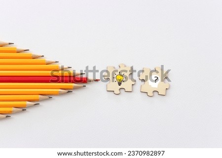 bright light bulb and question mark with pencils concept image Royalty-Free Stock Photo #2370982897
