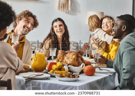happy multicultural family and friends having holiday dinner together on Thanksgiving day