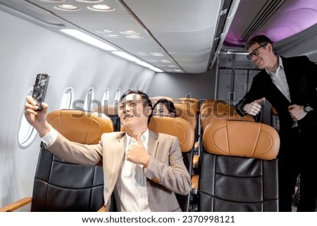 Senior businessman holding mobile phone to take selfie in comfortable seat inside airplane, male passenger on business trip in aircraft, businesspeople traveling with airline transportation. Royalty-Free Stock Photo #2370998121