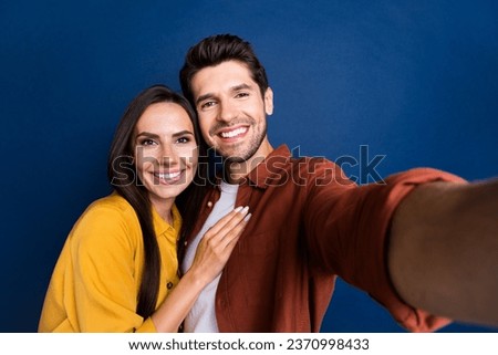 Portrait of two positive idyllic partners toothy smile cuddle take selfie isolated on dark blue color background Royalty-Free Stock Photo #2370998433