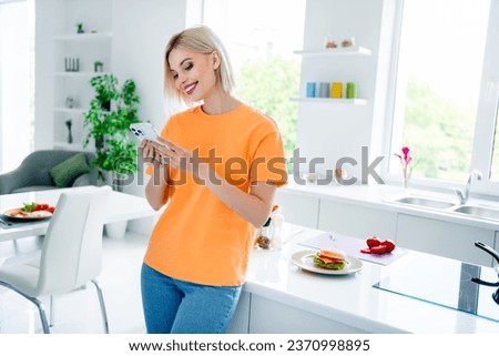 Photo of positive girl housewife use gadget for searching recipe dinner in modern kitchen house