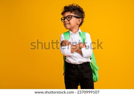 Photo of creative minded smart kid crossed hands carry bag look empty space brainstorming isolated on yellow color background