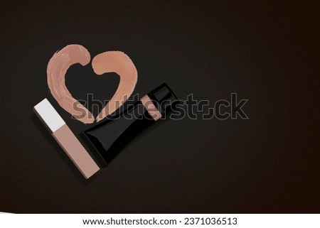Strokes of foundation in the shape of a heart. Black cream tube mockup. Product mock up, blank packaging for cosmetic products.