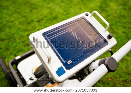 A Ground Penetrating Radar mounted on wheels, used to survey below the ground for archaology or to search for human remains in burial sites. Royalty-Free Stock Photo #2371039391
