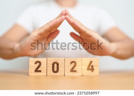 hand cover 2024 Year block. Insurance, protection, safety and New year holiday Concepts