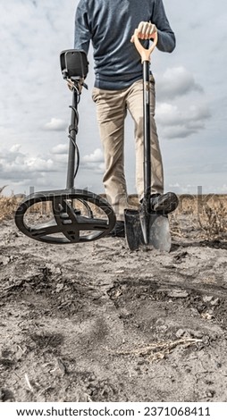 Archaeological and treasure hunting with a metal detector.Hunting for relics in the ground.Search for antiques.Soil research on gold nuggets.A man with a metal detector and a shovel.Finding  research Royalty-Free Stock Photo #2371068411