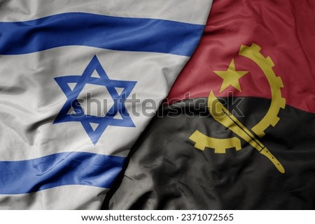 big waving national colorful flag of israel and national flag of angola . macro
