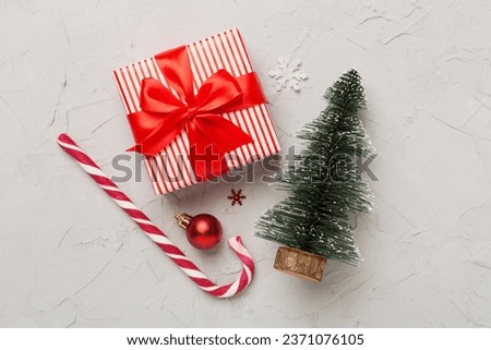Miniature christmas tree with gift box and decor on concrete background