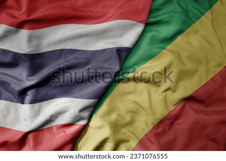 big waving national colorful flag of thailand and national flag of republic of the congo . macro