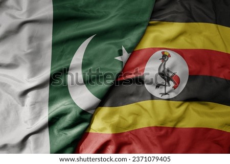 big waving realistic national colorful flag of pakistan and national flag of uganda . macro