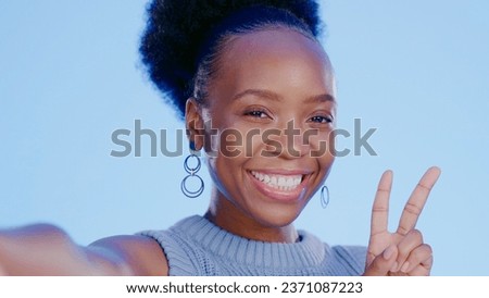 Happy, selfie and black woman with peace sign with smile isolated in a studio blue background as emoji. Happiness, cool or portrait of person with v hand gesture for social media picture online