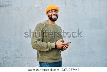 Phone, portrait and young man by wall networking on social media, mobile app or the internet. Technology, happy and person from Colombia scroll on website with cellphone in city by gray background.