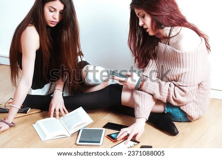 In a world filled with people, two young women grapple with new media's conflicts, juxtaposed against centuries-old intellectual legacies. Can we outshine those who came before? Royalty-Free Stock Photo #2371088005