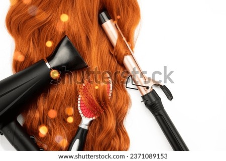 Long wavy red female hair, hair blow dryer, and Curling Iron on white isolated background. Hairdressing Products, coloring in bright colors. Hair care.