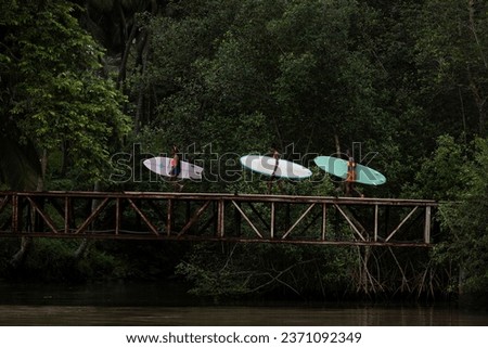 Side view of three beautiful black girls walking across a wooden bridge in Sao Tome and Principe, Africa Royalty-Free Stock Photo #2371092349