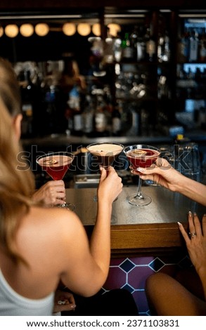 Triple Martini Elegance: Girls Toasting to Espresso and Red Delights