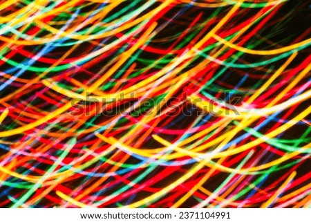 Long-exposure night photo, sweeping light curves, green, yellow, blue, red, high-contrast texture, unique composition, wallpaper.