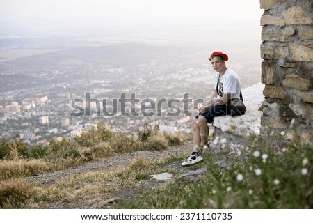 teenage boy walking on the mountain in the evening in summer