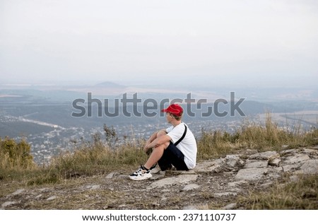 teenage boy walking on the mountain in the evening in summer