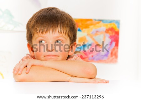 Thoughtful portrait of little boy lay on the table