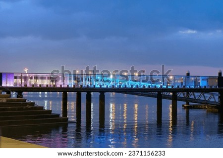 Waterfront pier illuminated at night in Tauranga city, New Zealand.