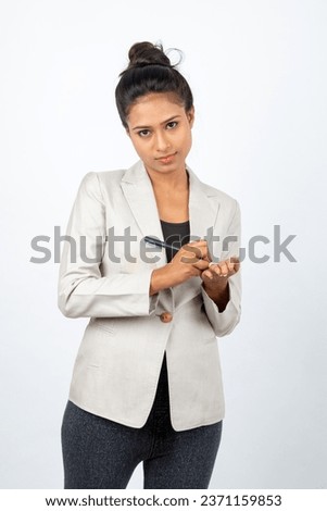Cheerful corporate office lady writing on her palm with a pen and giving presentation. Young woman in formal wear wearing white blazer against white background. 